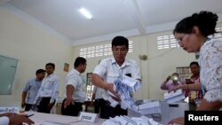 FILE - Members of the National Election Committee count ballots during a Senate election in Phnom Penh, Cambodia, Feb. 25, 2018. The committee was one of several organizations apparently caught up in a recent cyberattack engineered by the Chinese government, investigators allege.