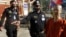FILE - Court securities direct Cambodian-American lawyer Theary Seng, right, dressed in a prison-style orange outfit, to the entrance of Phnom Penh Municipal Court in Phnom Penh, Cambodia, Tuesday, Jan. 4, 2022.