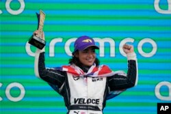 Jamie Chadwick, memegang trofi setelah memenangkan balapan mobil Seri W di Circuit of the Americas, di Austin, Texas, Minggu, 24 Oktober 2021. (Darron Cummings/AP)