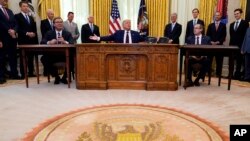 Predsednik SAD Donald Tramp govori nakon ceremonije potpisivanja sporazuma sa predsednikom Srbije Aleksandrom Vučićem (levo) i premijerom Kosova Avdulahom Hotijem, u Ovalnom kabinetu, u Beloj kući, 4. septembra 2020. (AP Photo/Evan Vucci)