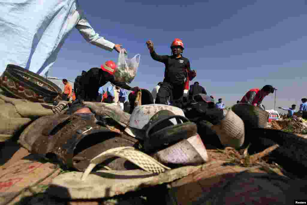 Rescue workers are seen collecting evidence behind footwear, after a bomb blast at a vegetable and fruit market in the outskirts of Islamabad, April 9, 2014.