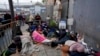 Para migran menunggu untuk mengajukan suaka di dekat pintu masuk Pelabuhan San Isidro, yang menghubungkan kota Tijuana, Meksiko dengan San Diego, California, AS.
