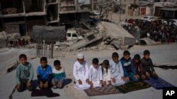 Warga Palestina salat di depan masjid yang hancur akibat serangan udara Israel di Rafah, Jalur Gaza, Jumat, 8 Maret 2024, menjelang bulan suci Ramadan. (Foto: AP/Fatima Shbair)