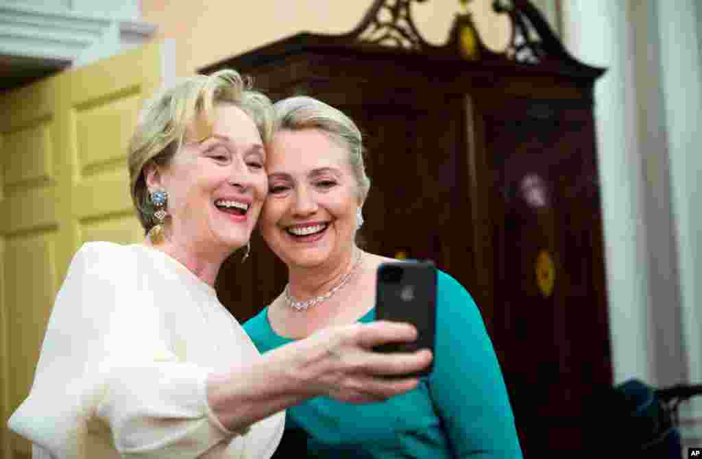 Nữ diễn viên Meryl Streep sử dụng iPhone để chụp ảnh với bà Clinton sau buổi dạ tiệc tại Bộ Ngoại Giao ở Washington, 1-12-2012 .