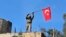 FILE -- In this Sunday, Jan. 28, 2018 file photo, a soldier waves a Turkish flag as Turkish troops secure Bursayah hill, near the Kurdish-held enclave of Afrin.
