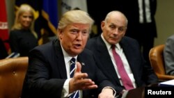 Menteri Keamanan Dalam Negeri Amerika Serikat John Kelly (kanan) mendengarkan Presiden Donald Trump dalam pertemuan dengan para ahli keamanan dunia maya di Gedung Putih (31/1). (Reuters/Kevin Lamarque)