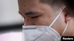 中国为死于冠状病毒病(COVID-19)的人举行全国哀悼活动，湖北省武汉市一名戴着口罩的男子哭泣。（2020年4月4日）