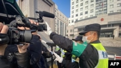 一名警察挡住记者的镜头阻止拍摄审讯公民记者张展的上海浦东新区法院外景。（2021年12月28日）