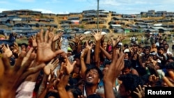 FILE PHOTO: Pengungsi Rohingya mengulurkan tangan untuk menerima bantuan yang didistribusikan oleh organisasi lokal di kamp pengungsi sementara Balukhali di Cox's Bazar, Bangladesh, 14 September 2017. (Foto: Reuters / Denmark Siddiqui)