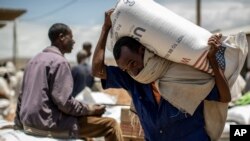 (Photo d’archives) Un Éthiopien porte sur ses épaules un sac de blé offert par l'USAID qui sera distribué par la Société de Secours du Tigré dans la ville d'Agula, dans la région du Tigré, dans le nord de l'Éthiopie, le samedi 8 mai 2021.