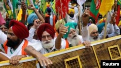 Petani meneriakkan slogan-slogan saat berlangsungnya aksi protes duduk menentang undang-undang pertanian, dekat gedung parlemen, di New Delhi, India, 22 Juli 2021. (REUTERS/Adnan Abidi)
