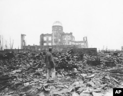 Seorang koresponden perang Sekutu berdiri di reruntuhan Hiroshima, Jepang, hanya beberapa minggu setelah kota itu diratakan oleh bom atom pada 1945. (Foto: AP)