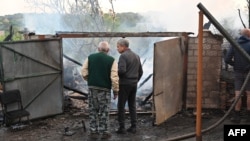 Penduduk setempat memeriksa sisa-sisa rumah mereka yang hancur akibat serangan pesawat tak berawak Rusia di pinggiran kota Kharkiv, 21 Mei 2024.
