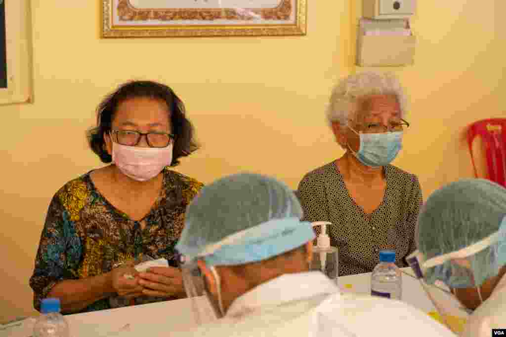 ប្រជាពលរដ្ឋដែលមានអាយុ ៦០ឆ្នាំឡើង អង្គុយរង់ចាំទទួលការចាក់វ៉ាក់សាំងការពារជំងឺកូវីដ១៩ របស់ក្រុមហ៊ុន AstraZeneca នៅមន្ទីរពេទ្យបង្អែករាជធានីភ្នំពេញ កាលពីថ្ងៃទី២៣ ខែមីនា ឆ្នាំ២០២១។ (ទុំ ម្លិះ/វីអូអេ)