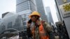 A worker uses a cell phone outside a construction site in Beijing on October 31, 2024. 