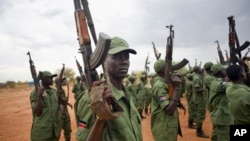 FILE - South Sudanese rebel soldiers raise their weapons at a military camp in the capital Juba, South Sudan.