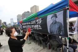 A mourner takes photos of the late South Korean Army Gen Paik Sun-yup at a memorial altar for him at the Gwanghwamun Plaza in Seoul, South Korea, July 12, 2020.