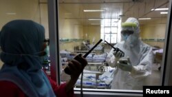 Pekerja kesehatan berbicara melalui walkie-talki di ruang isolasi untuk pasien virus corona (Covid-19) di Rumah Sakit Persahabatan, Jakarta, 13 Mei 2020. (foto: ilustrasi)