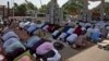 FILE - Indian Muslims offer Eid al-Fitr prayers in the shade of a petrol filling station as they join others offering prayers in an open area in Hyderabad, India, June 16, 2018. 