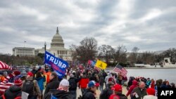 Pendukung Presiden AS Donald Trump berbaris melalui jalan-jalan kota saat mereka menuju Gedung Capitol di Washington DC pada 6 Januari 2021. (Foto: AFP)