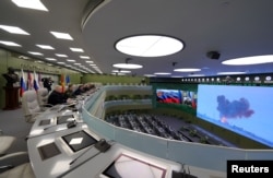 FILE - Russia's President Vladimir Putin (5th L) visits the National Defense Control Center (NDCC) to oversee the test of the new Russian hypersonic missile system Avangard, capable of nuclear and conventional warheads, in Moscow, Dec. 26, 2018.