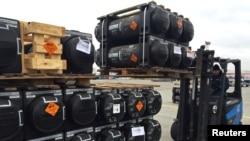 Bantuan militer dari Amerika Serikat untuk Ukraina sedang diturunkan dari pesawat di Bandara Internasional Boryspil di luar Kota Kyiv, Ukraina, 11 Februari 2022. (Foto: Serhiy Takhmazov/Reuters)