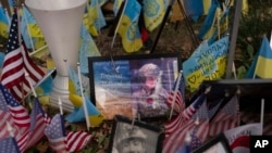 The memorial plate for Tatyana Millard, an American volunteer, is seen among Ukrainian and U.S. flags placed in honor of fallen servicemen in central Kyiv, Ukraine, Nov. 5, 2024.