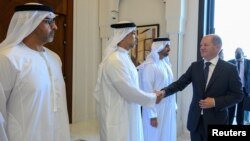Kanselir Jerman Olaf Scholz berjabat tangan dengan Wakil Perdana Menteri Sheikh Mansour bin Zayed al-Nahyan di Abu Dhabi, hari Minggu (25/9). 
