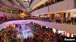 香港人在东京奥运举行期间在商场内观看香港游泳选手何诗蓓参加女子100米自由泳决赛并为她呐喊打气 （路透社照片）