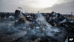 Palestinians look at the destruction after an Israeli strike where displaced people were staying in Rafah, Gaza Strip, May 27, 2024. 