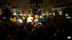 Orang-orang memegang balon-balon yang diberi pencahayaan saat mereka berkumpul untuk menandai Earth Hour di Madrid, 25 Maret 2017 (foto: AP Photo/ Francisco Seco)
