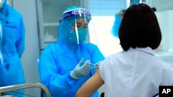 រូបឯកសារ៖ បុគ្គលិក​សុខាភិបាល​ម្នាក់ ​ចាក់​វ៉ាក់សាំង AstraZeneca សម្រាប់​បង្ការ​ជំងឺ​កូវីដ១៩ ដល់​វេជ្ជបណ្ឌិត​ម្នាក់​នៅ​មន្ទីរពេទ្យ​មួយ​ក្នុង​ទីក្រុង​ហាណូយ ប្រទេស​វៀតណាម ថ្ងៃទី៨ ខែមីនា ឆ្នាំ២០២១។ 