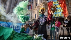 Aktivis dari kelompok iklim Extinction Rebellion berdemonstrasi di depan gedung pemerintah Distrik John Wilson di Columbia untuk menuntut diakhirinya semua infrastruktur bahan bakar fosil baru di Washington, AS, 22 April 2022. (Foto: REUTERS/Evelyn Hockstein)