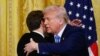 US President Donald Trump and French President Emmanuel Macron embrace at the end of a joint press conference in the East Room to the White House in Washington, DC, on February 24, 2025. (Photo by Ludovic MARIN / AFP)
