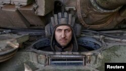 Seorang prajurit Ukraina melihat dari dalam tank di wilayah Donetsk, di tengah gempuran serangan Rusia ke Ukraina, Ukraina, 11 Juni 2022. (Foto: Reuters)