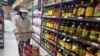 一名女子在北京一家超市里走过食用油货架。(2024年7月10日)