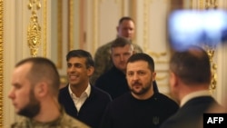 Ukrainian President Volodymyr Zelenskyy and British Prime Minister Rishi Sunak make their way to a meeting in Kyiv on Jan. 12, 2024.