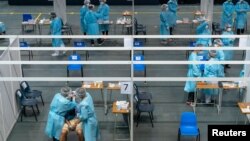 医护人员在香港的一个社区检测中心给市民进行新冠病毒检测。（2020年9月1日）