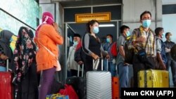 Buruh migran Indonesia tiba dari Malaysia di pelabuhan Bandar Sri Junjungan di Dumai, Riau pada 2 April 2020, setelah Indonesia menyatakan keadaan darurat pada 31 Maret akibat virus corona melonjak. (Foto: AFP/Iwan CKN)