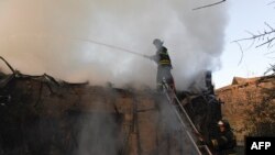 Petugas pemadam kebakaran berusaha memadamkan api di sebuah rumah yang terkena serangan Rusia di Donetsk, Ukraina, pada 24 Oktober 2023. (Foto: AFP/Stringer)