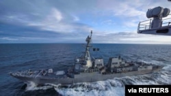 资料照片:美国海军"基德号"导弹驱逐舰在阿拉斯加湾参加演习时与"西奥多·罗斯福号”航空母舰并肩行驶。(2018年5月16日)
