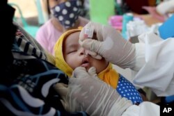Seorang bayi menerima vaksinasi polio di sebuah puskesmas di Tangerang, 12 Mei 2020. (Foto: AP/Tatan Syuflana)