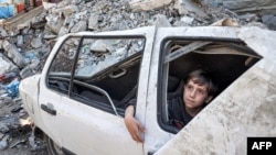 Palestinski dečak posmatra ruševine u Rafi na jugu Gaze, 9. april 2024. (AFP)