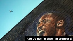 Sebuah helikopter terbang di atas mural Kobe Bryant di pusat kota Los Angeles, 26 Januari 2020. Sembilan orang tewas dalam kecelakaan helikopter yang merenggut nyawa bintang NBA Kobe Bryant dan putrinya yang berusia 13 tahun. (Foto: AFP/Apu Gomes)