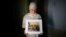 FILE - Maryam Kamalmaz holds a photo of her father, Majd Kamalmaz, with some of his 14 grandchildren in Grand Prairie, Texas, Jan. 17, 2024. The Syrian-born American psychotherapist died while being held in Syria. His family has filed a lawsuit against the Syrian government.