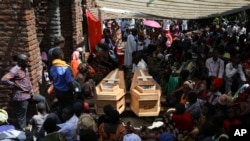 Des proches pleurent Florence Masika et son fils Zakayo Masereka, lors de leurs funérailles à Nyabugando, en Ouganda, le dimanche 18 juin 2023.