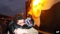 FILE - A freed Syrian prisoner, left, hugs his brother after being released from Adra Prison on the northeast outskirts of Damascus, Syria, on Jan. 16, 2012. 