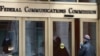 FILE - In this Dec. 14, 2017, file photo, a person enters the Federal Communications Commission building in Washington. 