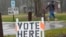 FILE - A voter braves a cold rain running to cast a ballot during the spring election, April 2, 2024, in Fox Point, Wisconsin.