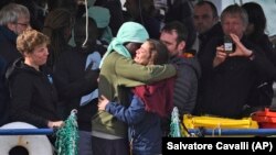 Seorang migran Afrika memeluk awak kapal 'Sea-Watch 3' saat diizinkan mendarat di pelabuhan Catania, Italia selatan (foto: ilustrasi). 